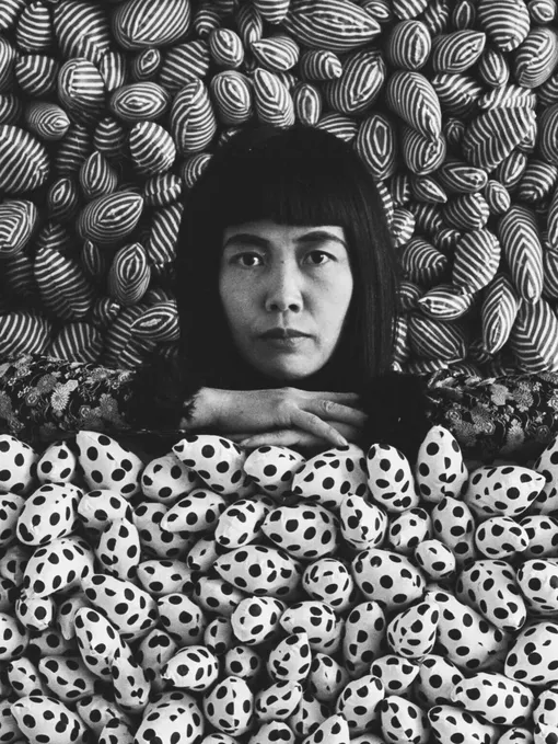 Яеи Кусама на фоне инсталляции «Поле фаллосов», 1965 год Яеи Кусама на фоне инсталляции «Поле фаллосов», 1965 год