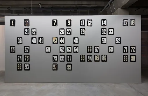 Аслан Гайсумов «Номера», 2015 год. 50 металлических номерных знаков. 20х80 см каждый. Предоставлено художником и Zink Gallery