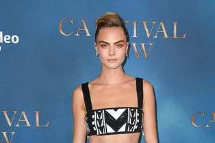 Оранжевые тени и кроп-топ с длинной юбкой: Кара Делевинь в Balmain на премьере