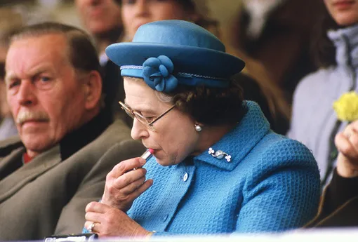 Королева Елизавета II красит губы во время Королевского конного шоу в Виндзоре, 11 мая 1985 года.