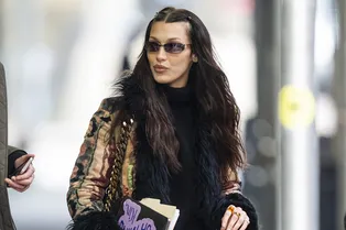 «Пальто-гобелен» с мехом и красные кожаные перчатки: Белла Хадид спешит в гости к сестре Джиджи