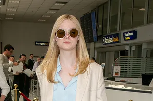 Эль Фаннинг в бежевом костюме с голубой рубашкой и красной сумкой прилетела в Канны