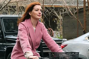 Энн Хэтэуэй в пальто Max Mara катается на велосипеде по морозному Нью-Йорку