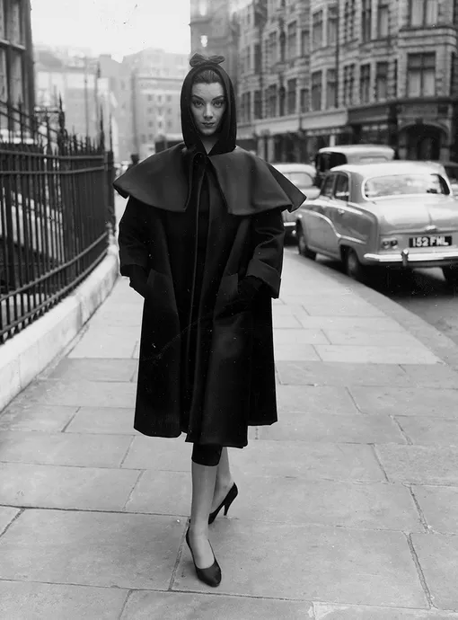 МОДЕЛЬ В ПАЛЬТО И ПЛАТЬЕ BALENCIAGA ВО ВРЕМЯ РЕПЕТИЦИИ ТЕЛЕШОУ FASHIONS FROM PARIS, 1955